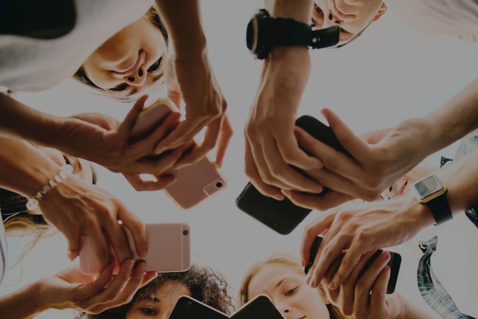 Crowd of people looking down at their phones