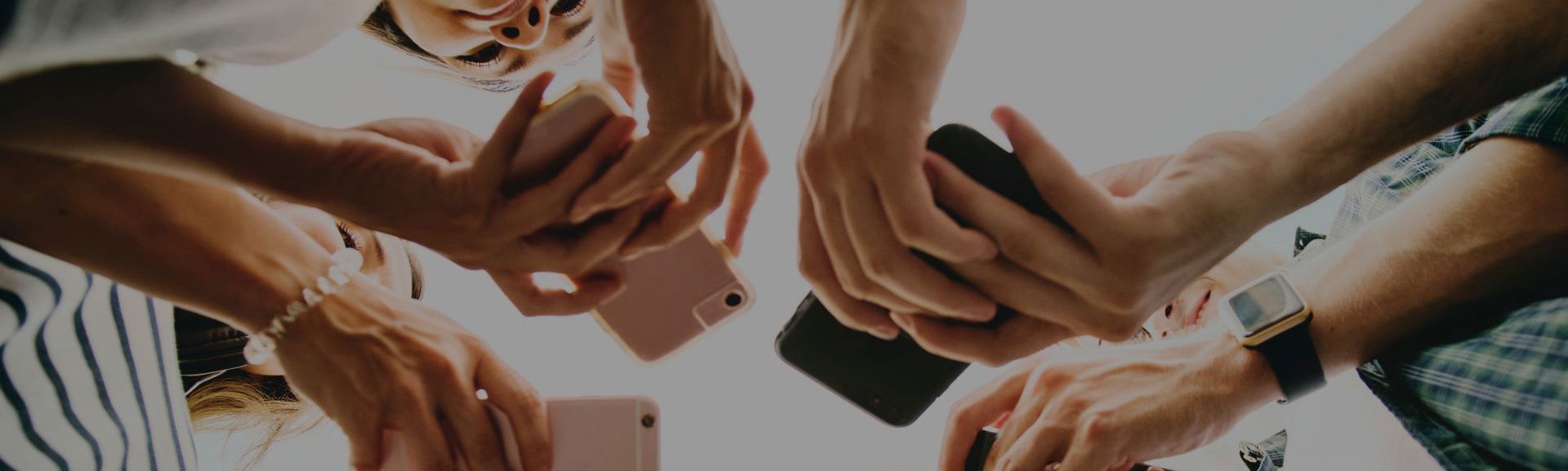 Crowd of people looking down at their phones